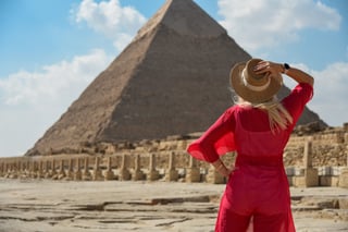 A Girl In A Red Dress Looks At An Egyptian Pyramid