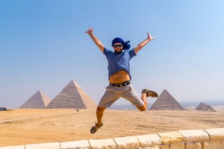 A Young Tourist Jumping For Joy In A Blue Turban And Sunglasses At The Pyramids Of Giza The Oldes