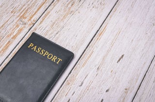Black passport on wooden surface