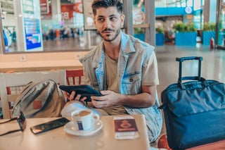 Cheerful man at airport coffee lounge