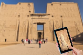 Hands Of Tourist Touching Tablet Screen With A Focused Horus Statue In Edfu Temple Intentionallym