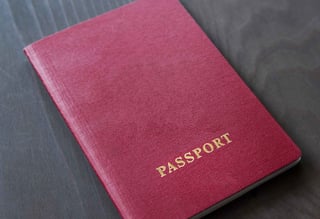 Red passport on wooden surface