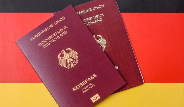 German Citizen Passport Against The Background Of The German National Flag